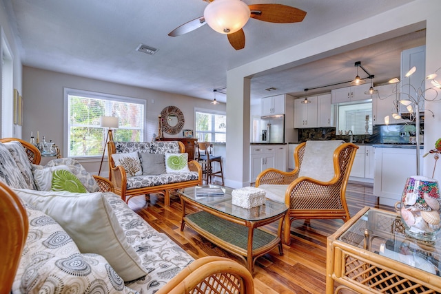 living room with ceiling fan, light hardwood / wood-style floors, and sink