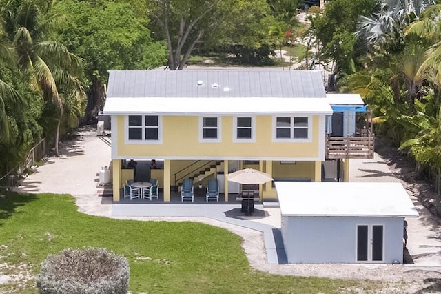 rear view of property featuring a patio and a lawn