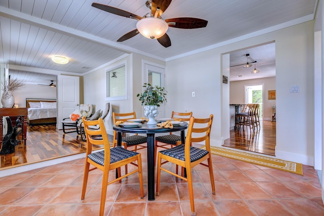 dining space with beamed ceiling, ornamental molding, wooden ceiling, and tile patterned floors