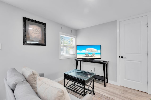 living area featuring baseboards and light wood-type flooring