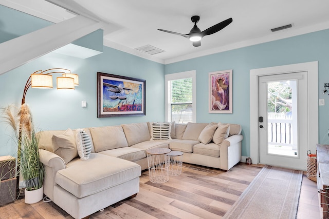 living room with visible vents, light wood-style flooring, and ceiling fan