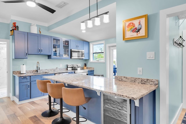 kitchen with a sink, beverage cooler, stainless steel appliances, a peninsula, and visible vents