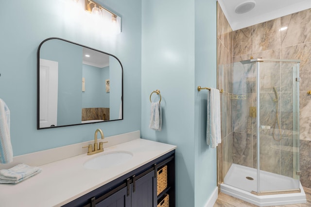 bathroom featuring vanity, baseboards, and a stall shower