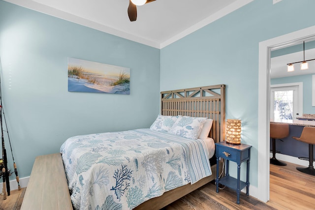 bedroom with baseboards, a ceiling fan, and wood finished floors