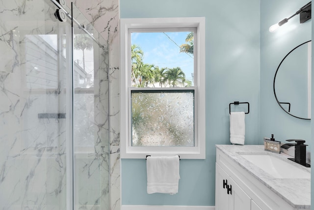 bathroom featuring a marble finish shower and vanity