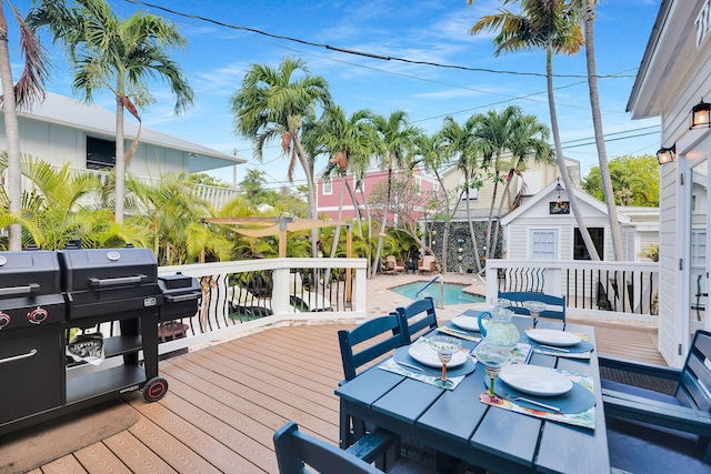 wooden terrace with a community pool and area for grilling
