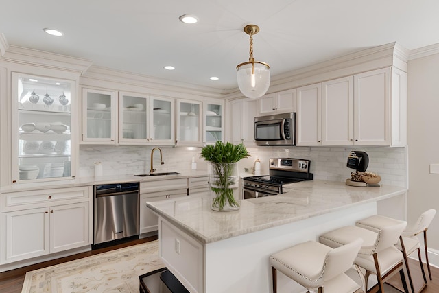 120 9th St, Key Colony, FL 33051 - kitchen with stainless steel appliances, a peninsula, light stone countertops, glass insert cabinets, and decorative backsplash