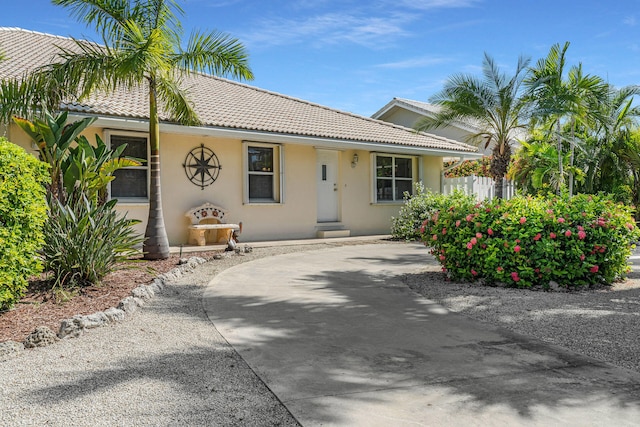 120 9th St, Key Colony, FL 33051 - view of front of house with a tile roof, stucco siding, and curved driveway