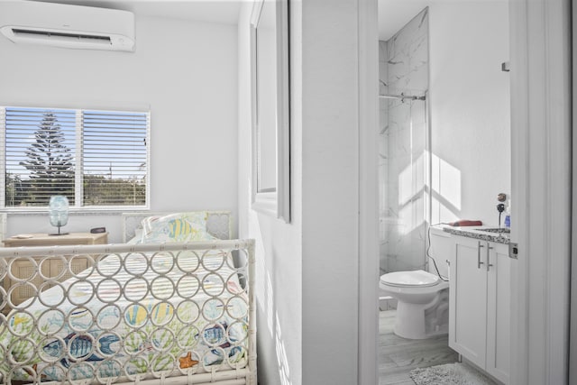 bathroom featuring vanity, toilet, and an AC wall unit