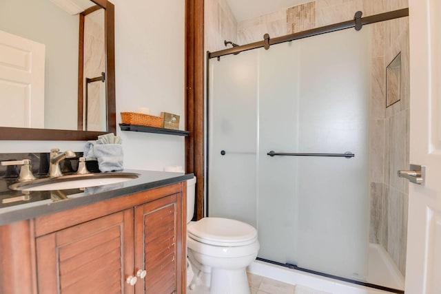 bathroom with vanity, toilet, tile patterned floors, and walk in shower