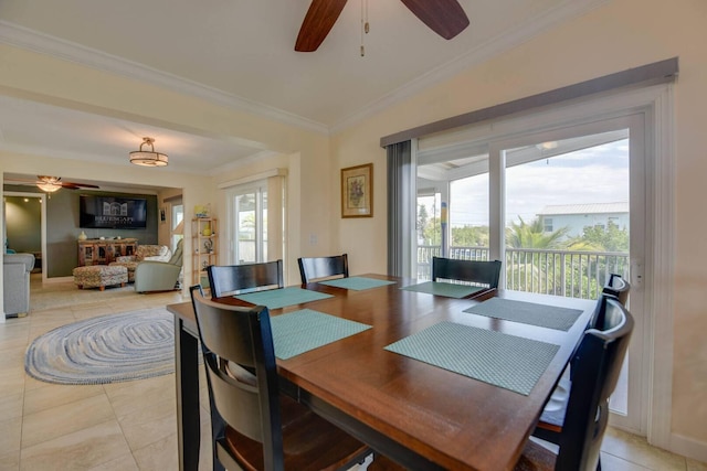 tiled dining area with a wealth of natural light, ornamental molding, and ceiling fan