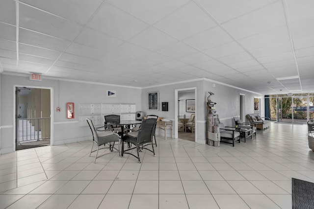 dining area with a paneled ceiling, ornamental molding, and light tile patterned flooring