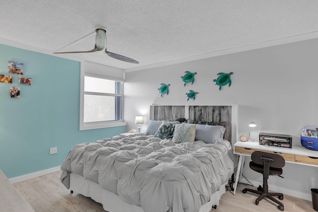 bedroom featuring ceiling fan, a textured ceiling, and light wood-type flooring