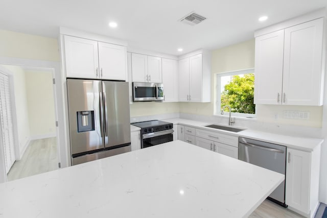 365 Pirates Rd, Little Torch, FL 33042 - kitchen with visible vents, light stone countertops, white cabinets, a sink, and appliances with stainless steel finishes