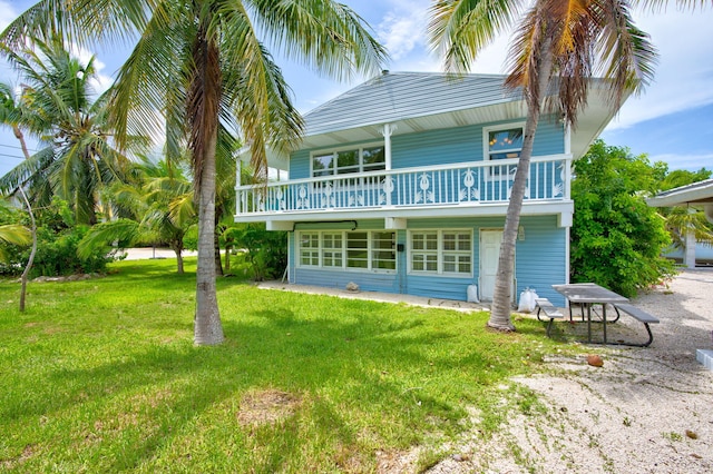22841 Buccaneer Ln, Cudjoe, FL 33042 - rear view of house with a balcony and a lawn