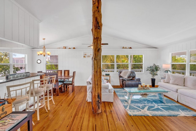 22841 Buccaneer Ln, Cudjoe, FL 33042 - living room featuring light wood finished floors, a chandelier, healthy amount of natural light, and wooden walls