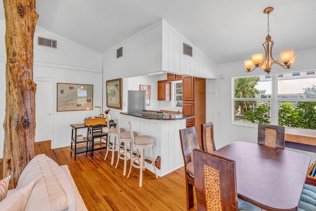 22841 Buccaneer Ln, Cudjoe, FL 33042 - dining room with light wood-style flooring, a chandelier, crown molding, and vaulted ceiling