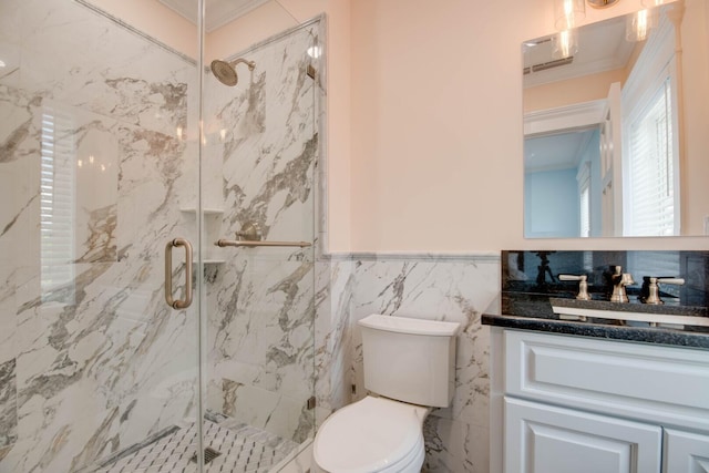 bathroom featuring tile walls, vanity, ornamental molding, toilet, and a shower with door