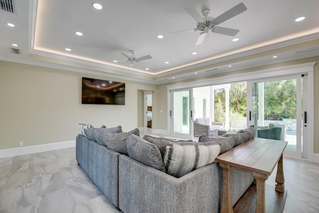 living room featuring crown molding, ceiling fan, and a tray ceiling