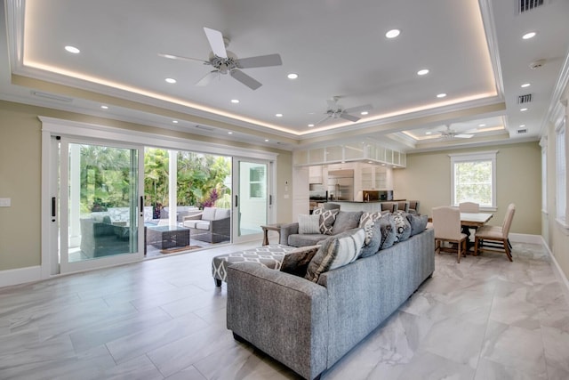 living room with ornamental molding and a tray ceiling