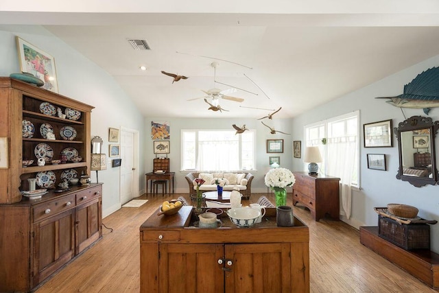 living room featuring lofted ceiling, a wealth of natural light, and light wood-type flooring