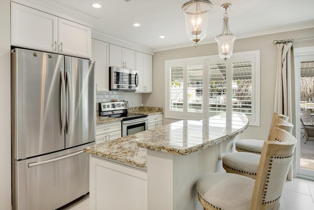 240 S Coconut Palm Blvd, Tavernier, FL 33070 - kitchen featuring stainless steel appliances, tasteful backsplash, white cabinets, light stone countertops, and a kitchen island
