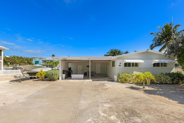 240 S Coconut Palm Blvd, Tavernier, FL 33070 - rear view of house with concrete driveway, an attached carport, and stucco siding