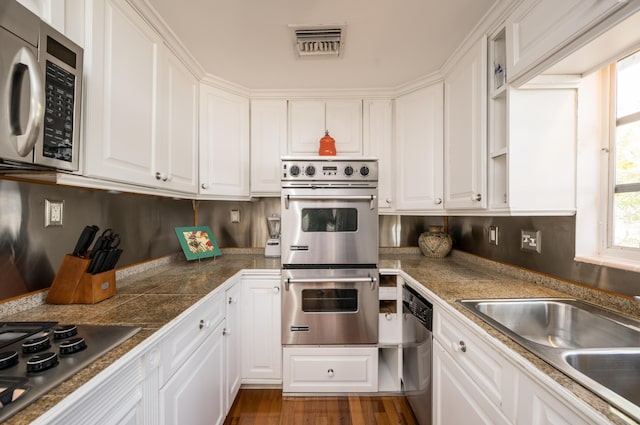 718 Chapman Ln, Key West, FL 33040 - kitchen featuring appliances with stainless steel finishes, white cabinetry, tile countertops, and dark wood finished floors