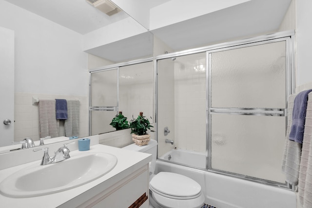 95 Coco Plum Dr Unit 2D, Marathon, FL 33050 - bathroom with vanity, combined bath / shower with glass door, toilet, and tile walls