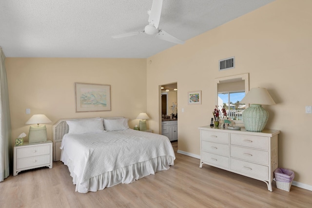 95 Coco Plum Dr Unit 2D, Marathon, FL 33050 - bedroom featuring lofted ceiling, light wood-style flooring, a textured ceiling, ensuite bathroom, and baseboards