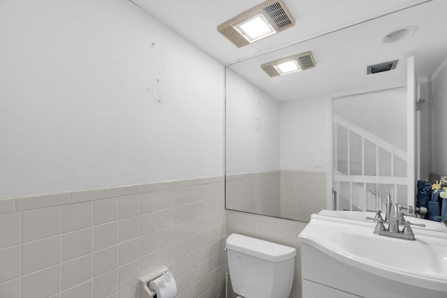 95 Coco Plum Dr Unit 2D, Marathon, FL 33050 - bathroom with toilet, vanity, tile walls, and a wainscoted wall