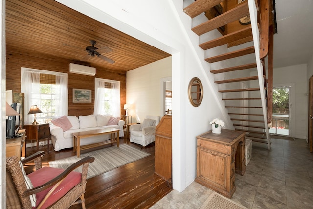 living room with ceiling fan, wood walls, a wall mounted air conditioner, and wooden ceiling