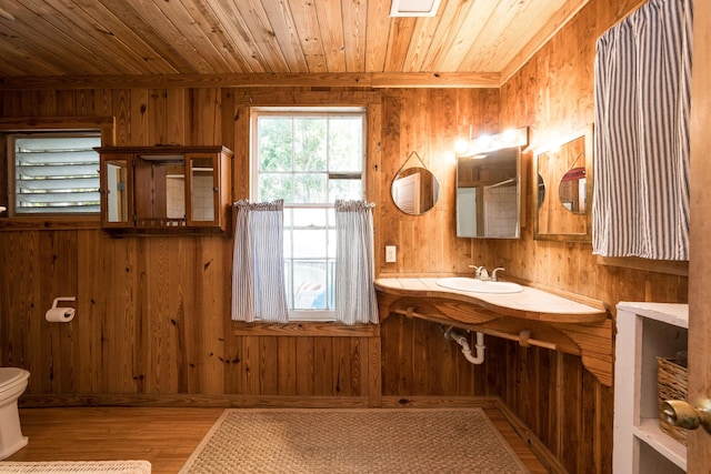 bathroom featuring wooden walls, sink, and wood ceiling