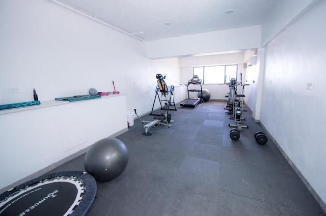 workout room featuring a wall mounted air conditioner