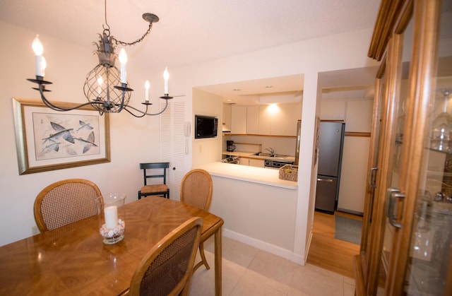 tiled dining area featuring sink and a notable chandelier