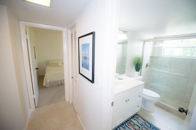 bathroom featuring tile patterned flooring, vanity, a shower with door, and toilet