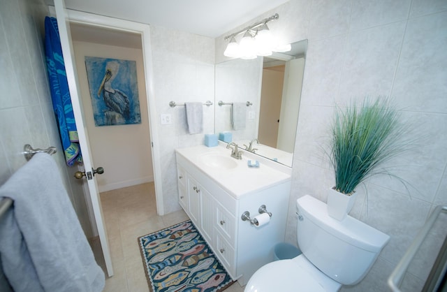 bathroom with vanity, tile walls, tile patterned floors, and toilet