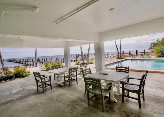 view of patio with a community pool and a water view