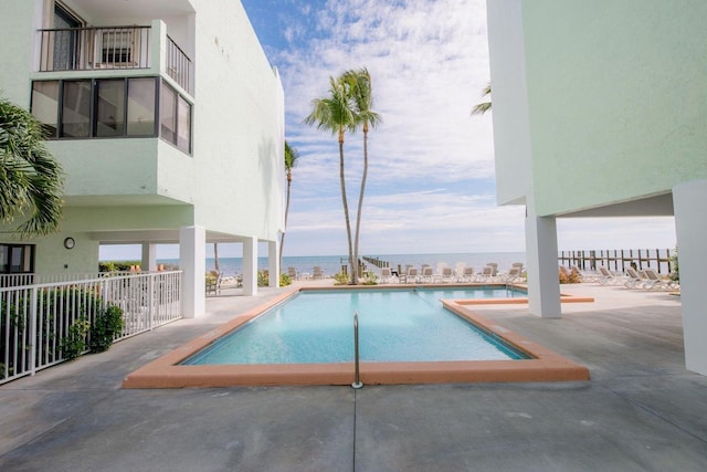 view of pool featuring a water view and a patio area