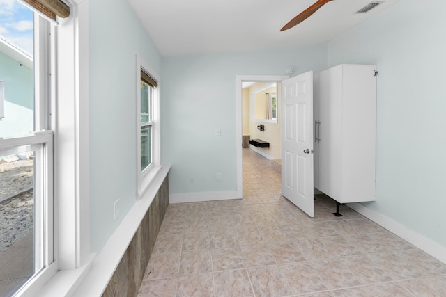 tiled spare room with ceiling fan