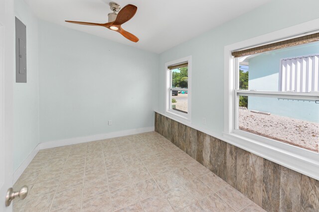 interior space featuring ceiling fan and wood walls