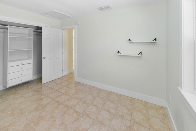 unfurnished bedroom featuring light tile patterned flooring, ceiling fan, and a closet