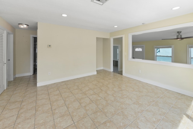 tiled spare room with ceiling fan