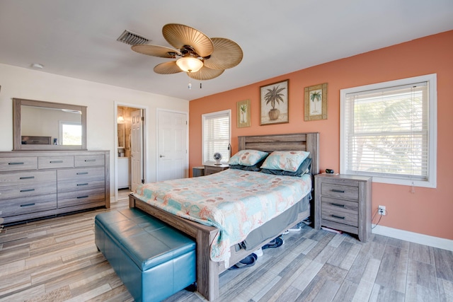 bedroom featuring ceiling fan, multiple windows, and light wood-type flooring