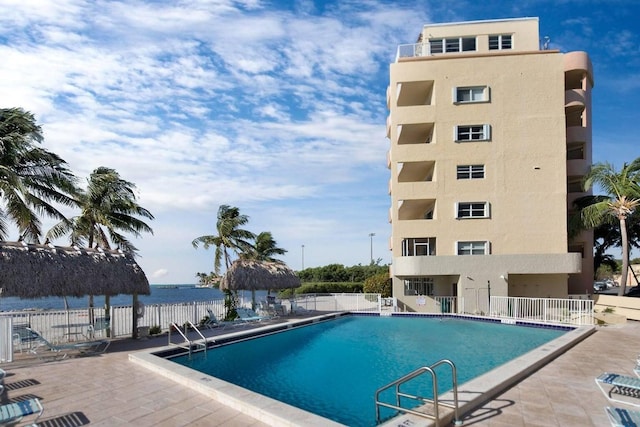 view of pool with a patio and a water view