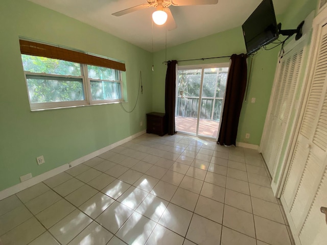 unfurnished bedroom featuring light tile patterned flooring, ceiling fan, lofted ceiling, and access to exterior