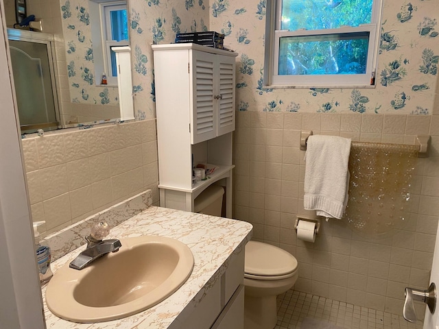 bathroom featuring vanity, tile patterned flooring, tile walls, and toilet