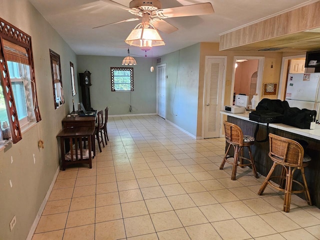 tiled dining area featuring bar and ceiling fan