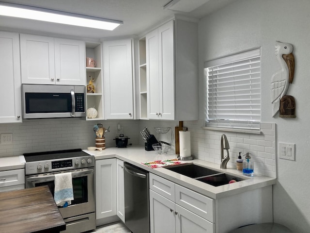 kitchen featuring appliances with stainless steel finishes, sink, and white cabinets