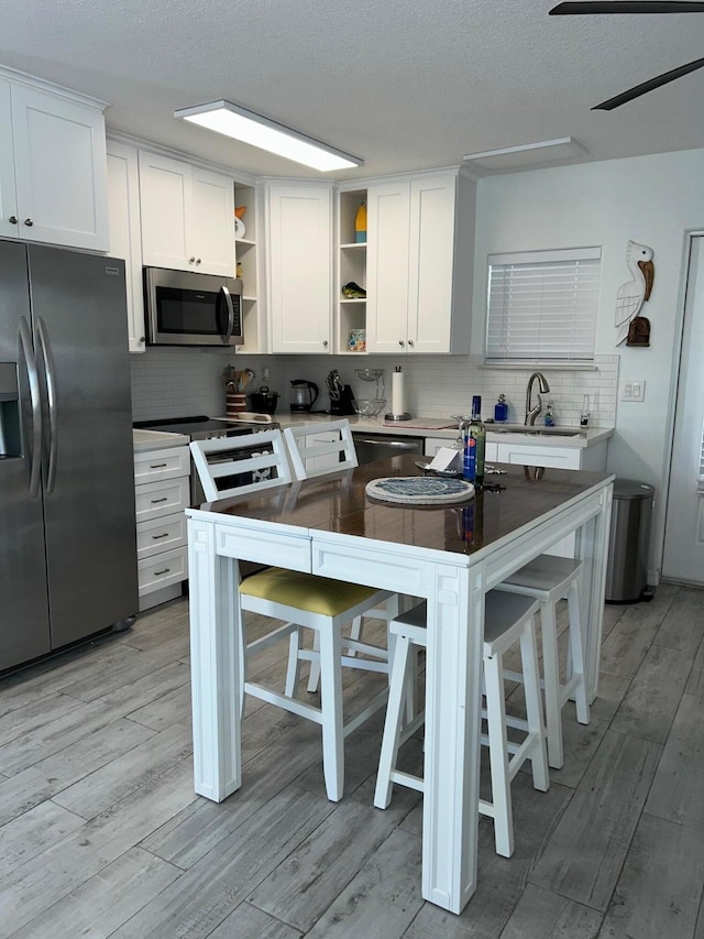 kitchen featuring white cabinetry, a breakfast bar, and appliances with stainless steel finishes